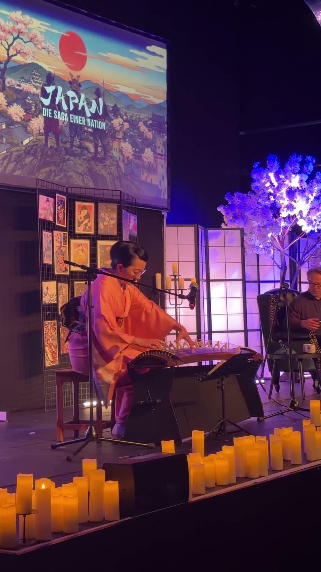 Koto-Spielerin und Bühne mit Japan-Projektion, aus dem Publikum fotografiert